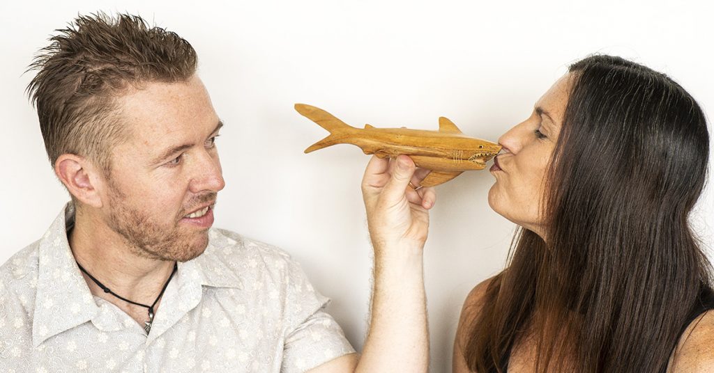 Tim and Anita Horan play with a wooden shark.