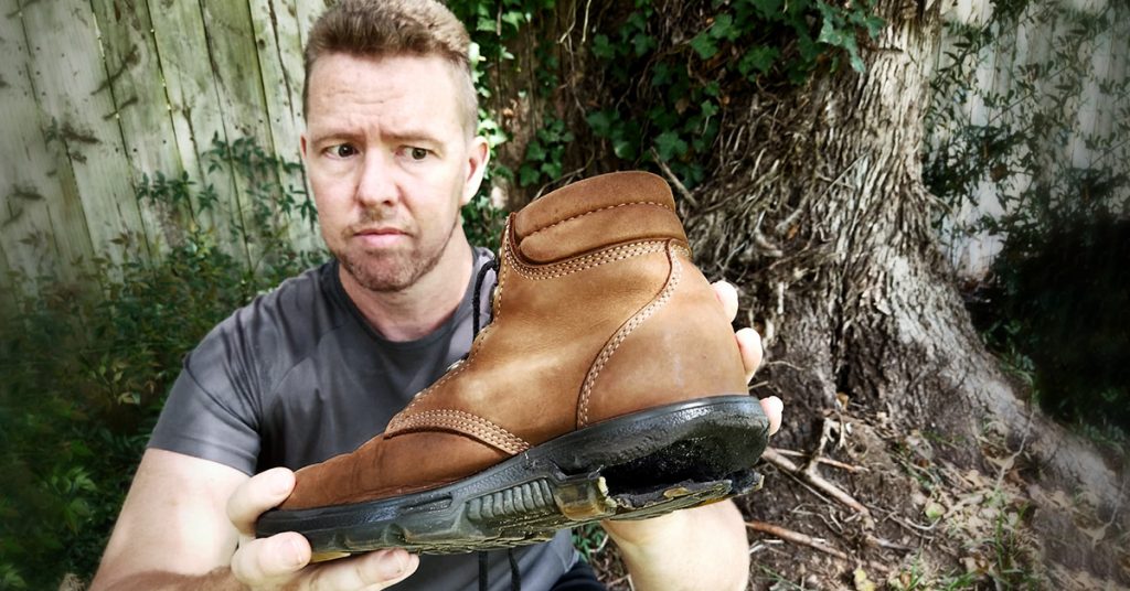 Tim Horan holds one of his hiking boots with a ruined heel.